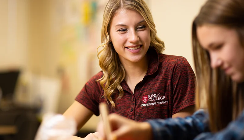 student working with a girl in a classroom setting earning their otd degree