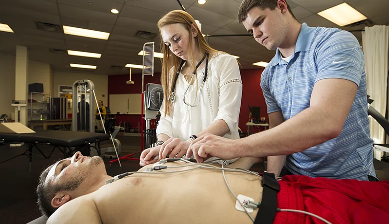 exercise science degree students measuring another student's pulse