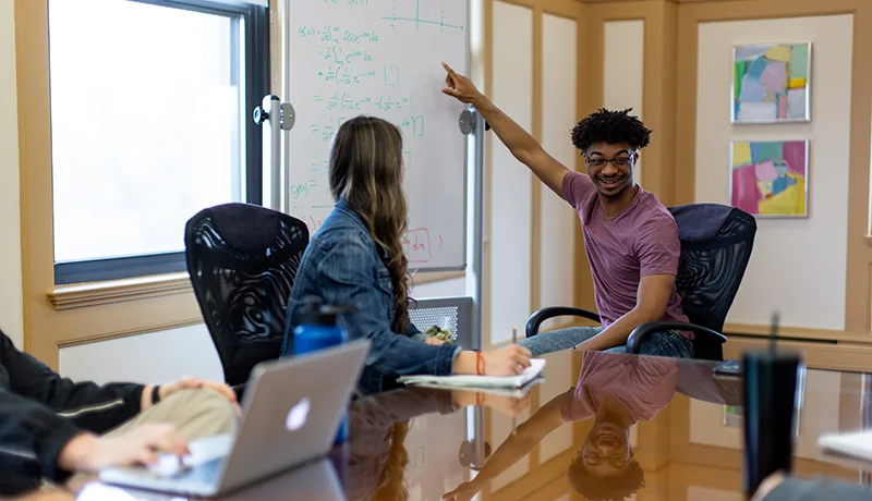 mathematics degree student pointing at a whiteboard