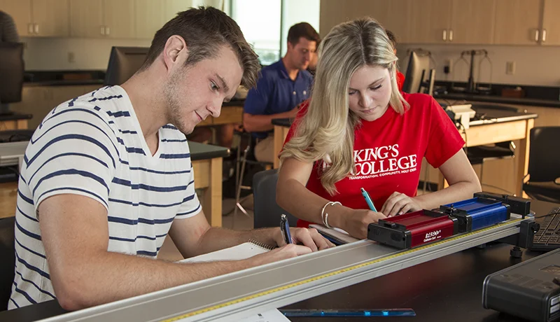 physics degree students writing on notebooks in a classroom