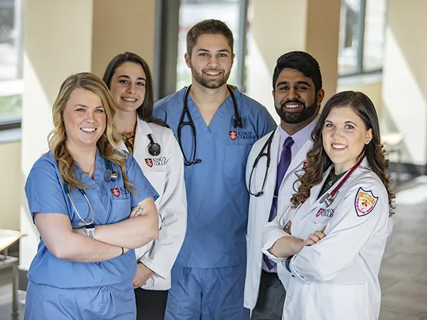group of people posing in labcoats at King's occupational therapy school
