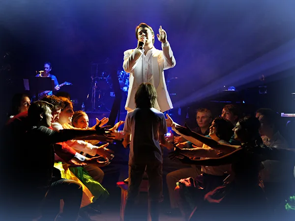 a man poses on a stage as part of a theatre production, an example of what jobs you can get with a communications degree