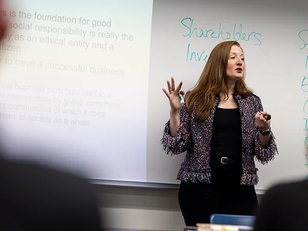 professor lecturing in front of a projector screen