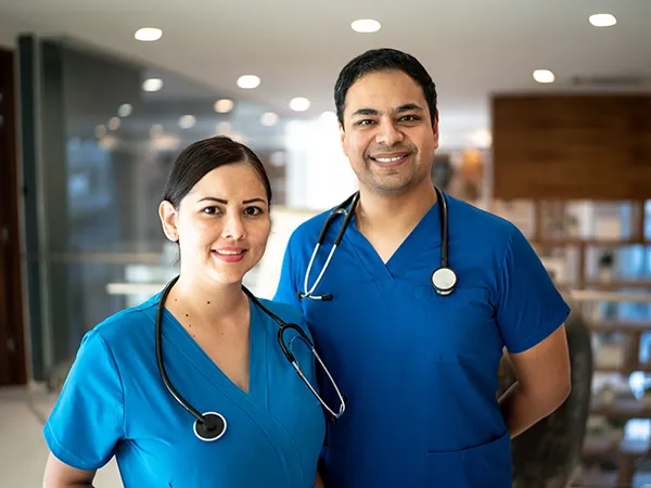 two medical professionals posing in scrubs