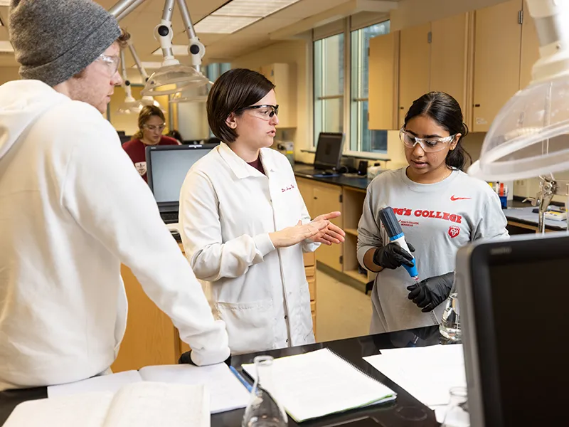 students in lab coats talking to eachother