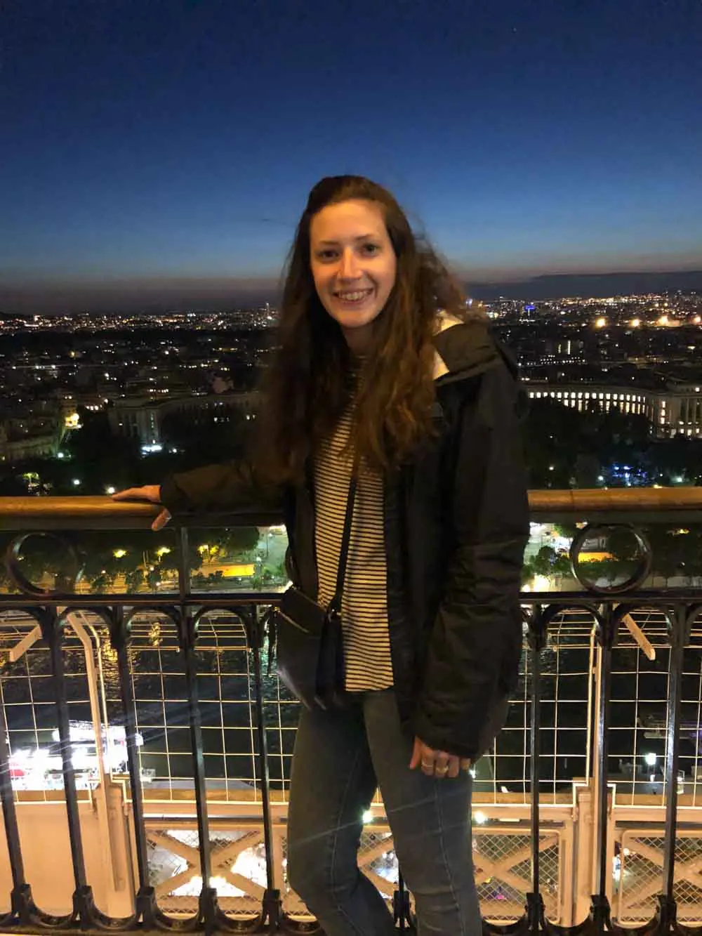 woman stands on balcony in foreign city